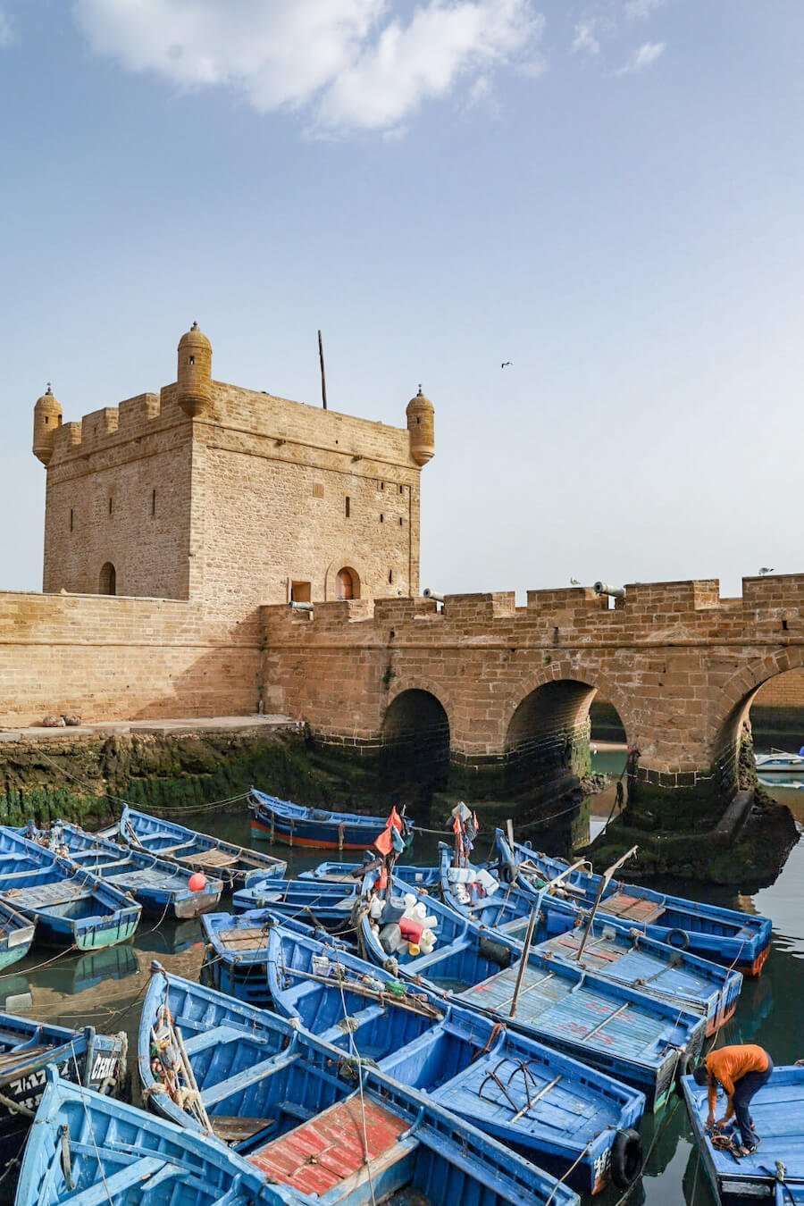 The Skala and ramparts of the Essaouira port and medina with blue fishing boats.