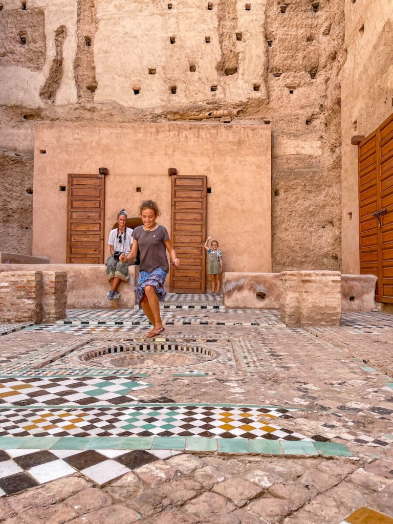 Children run through the El Badi Palace ruins in Marrakech Morocco.