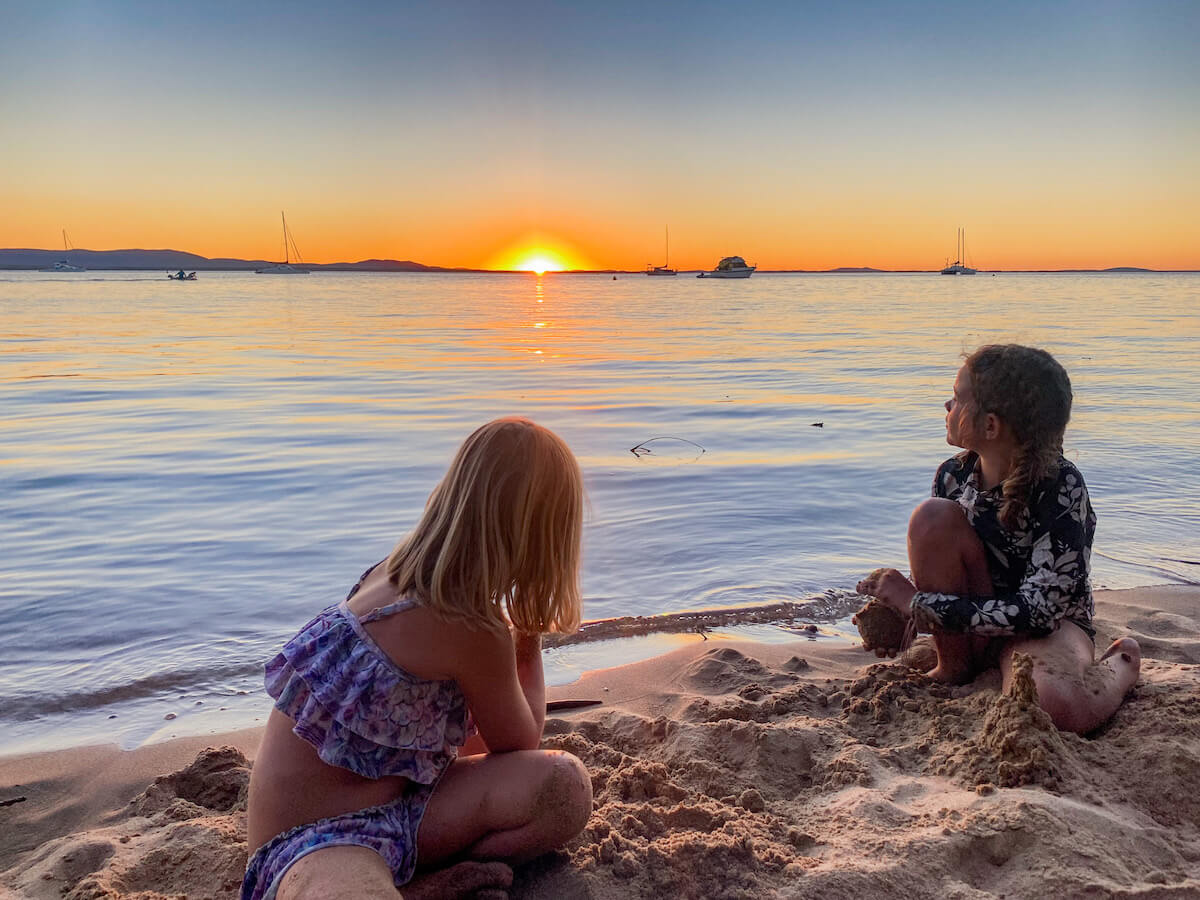Two kids watch the sunset on the beach at 1770, Agnes Water... watching the sunset is one of the popular activities to do in Agnes Water