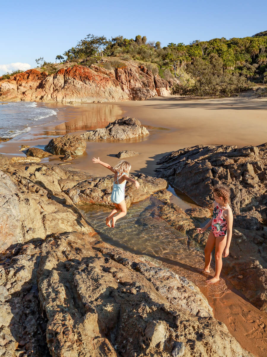 Kids jump into rock pools at Agnes Water in Australia, this is one of the best beaches to visit and one of the best walking activities to do if visiting