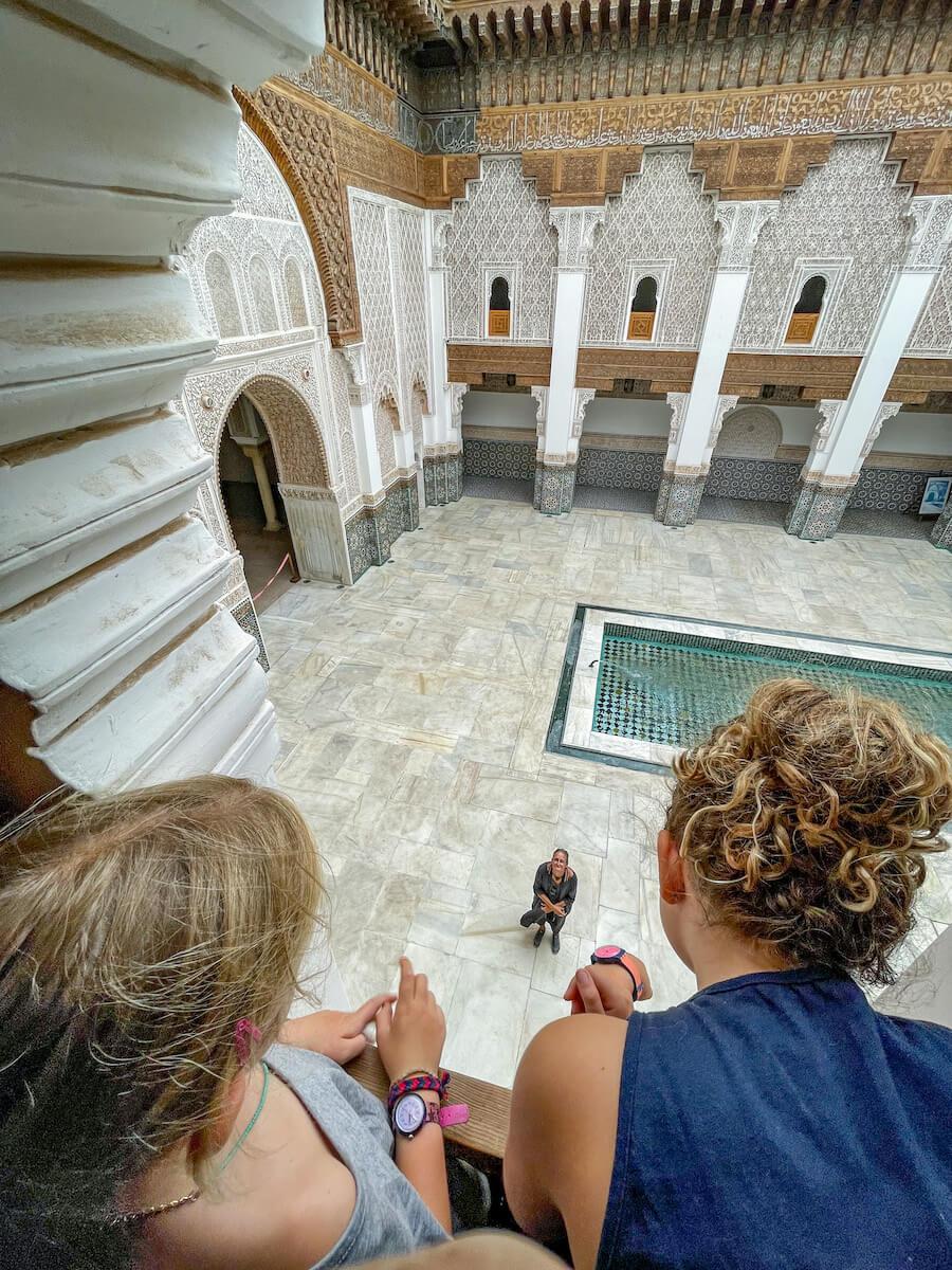 Children look out a window in the Ben Youssef Madrasa in Marrakech, Morocco