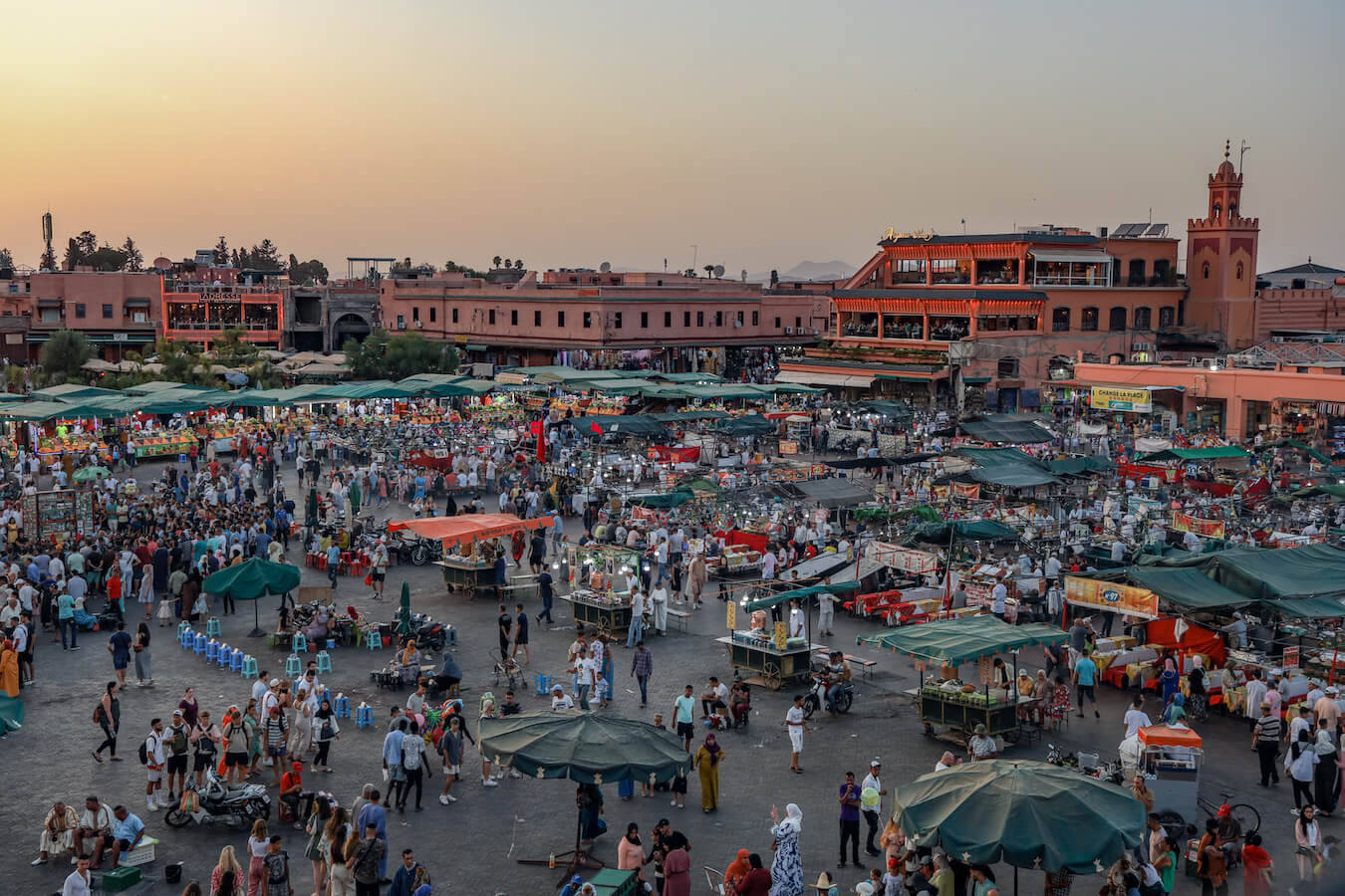 The sunsets over Djemaa el-Fna Square in Marrakech and it's full of people and action including many tourists.  This is one of the top things to do in Marrakech on a 3 days itinerary.