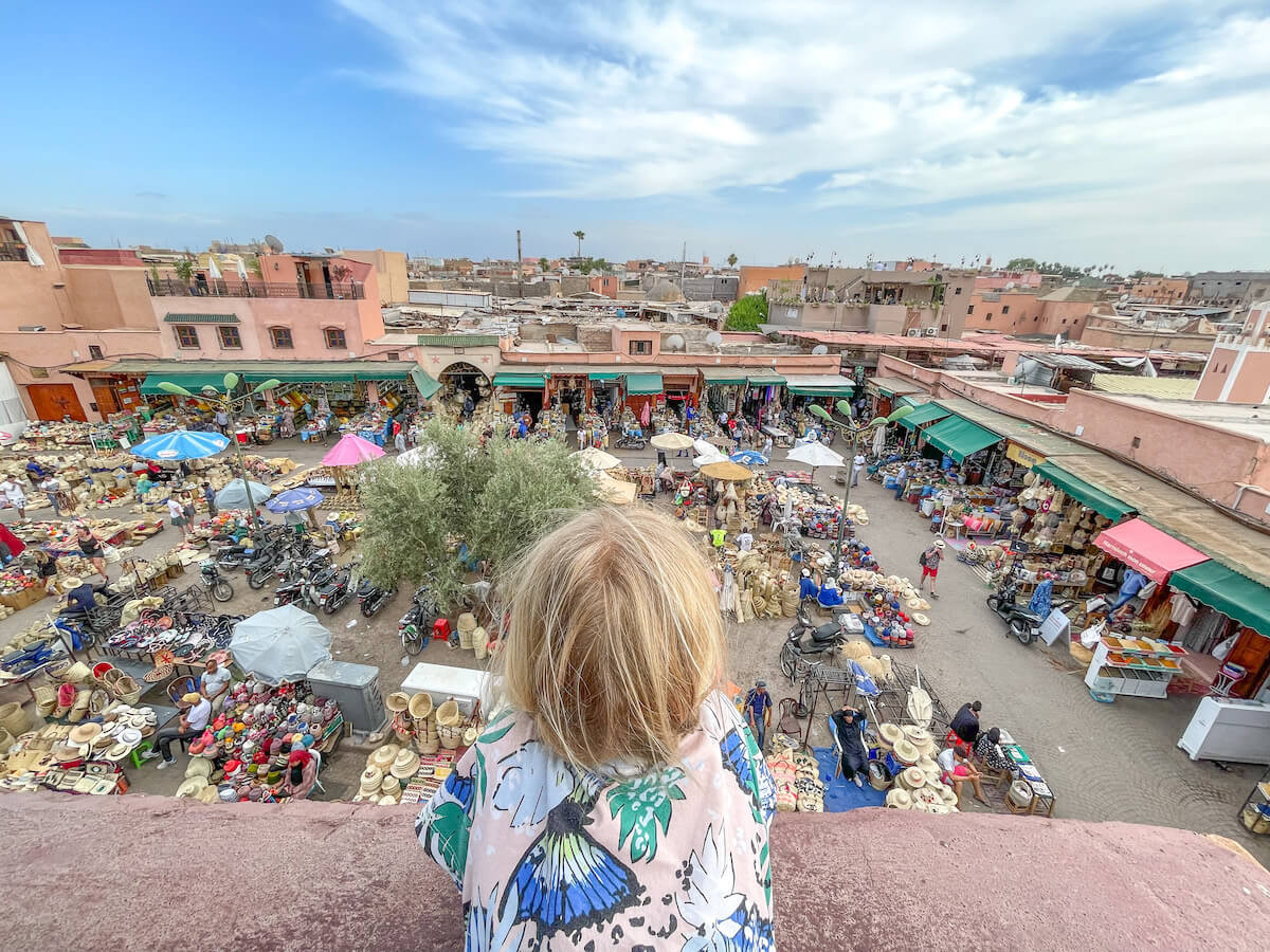 A child overlooks the Spice Square or Place des Espices in Marrakech, looking down from Cafe des Espices