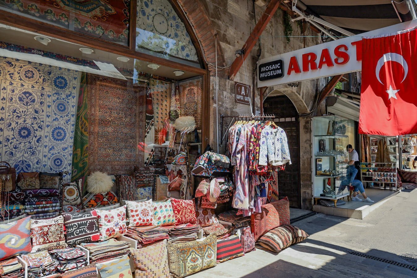 The Arasta Bazaar in Istanbul Sultanahmet District.  Carpets, cushions and clothes line the shop entrance.