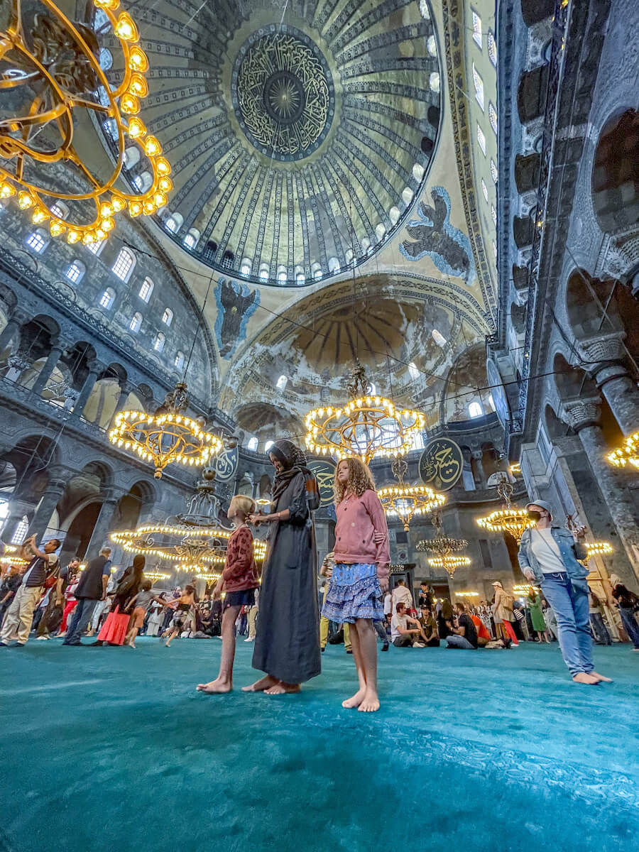 Mother and children stand in the middle of the Hagia Sophia in Istanbul
