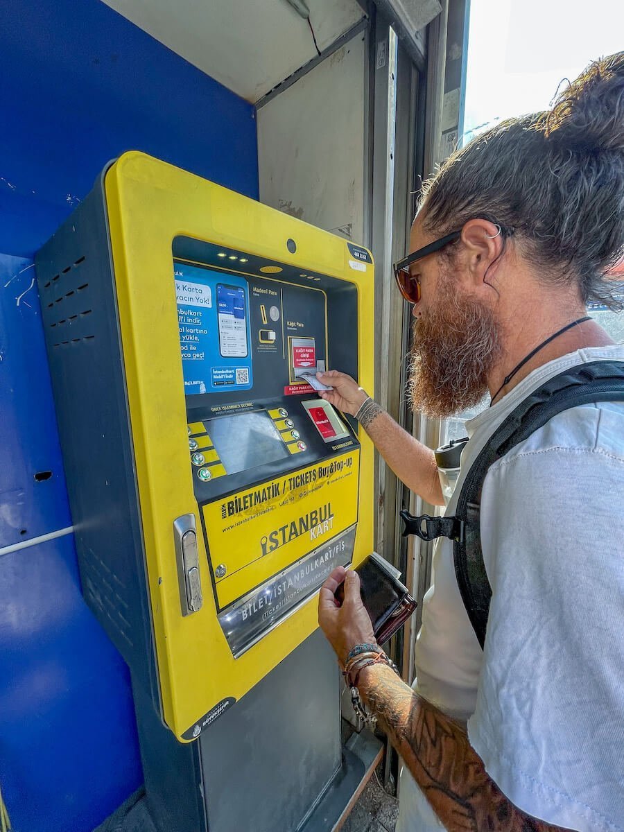 Man buys a public transport ticket from the Biletmatik kiosk.