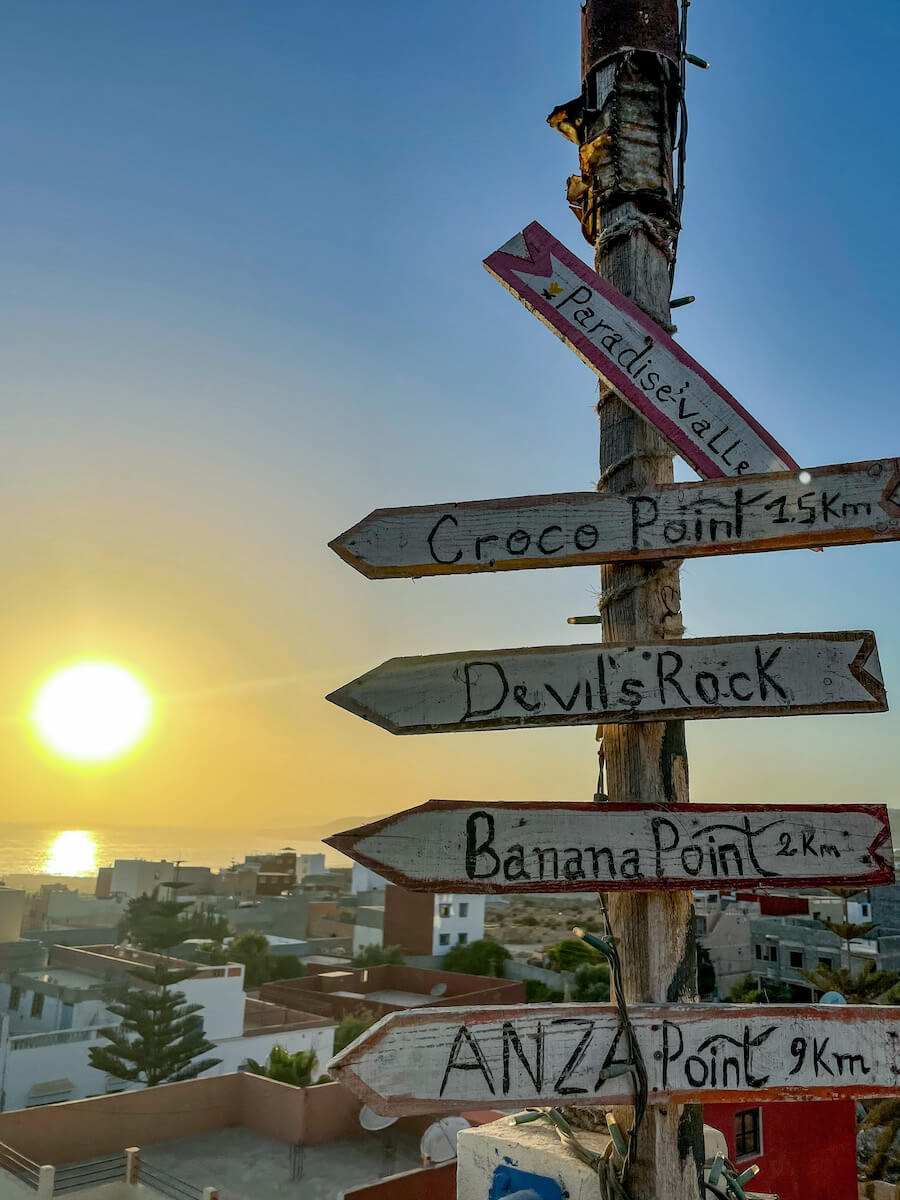 A sign pointing towards surf breaks along the Atlantic Coast from a hostel in Tamraght, Morocco.
