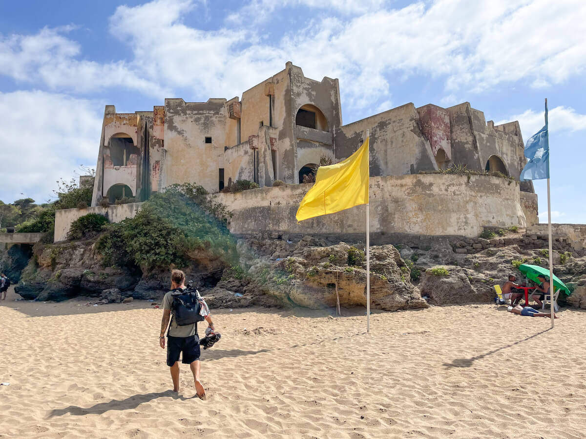 A man walks in front of a ruined building on Achakkar Beach near Tangier