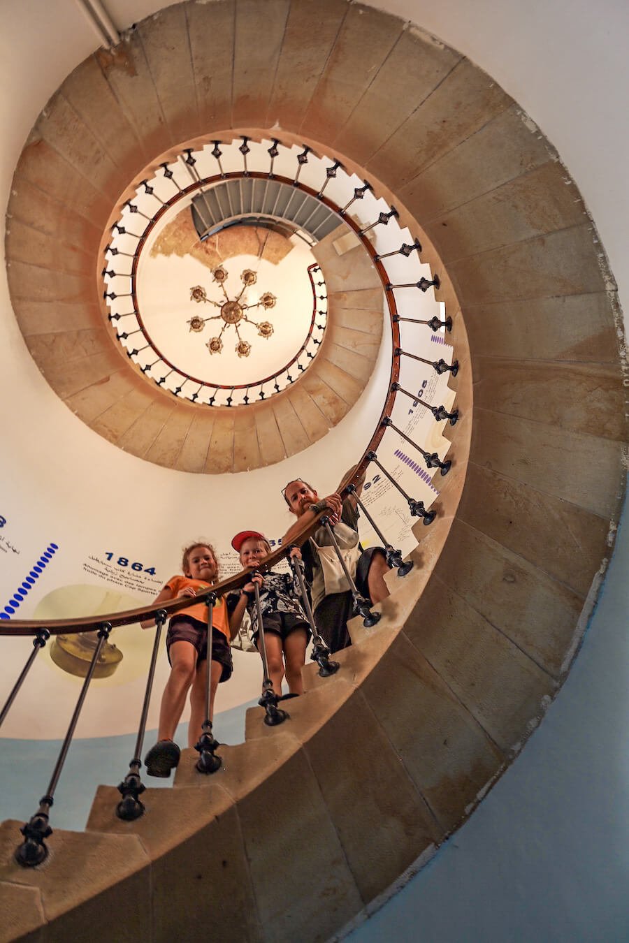 A family on a day trip from Tangier look down from the spiral staircase of Cape Spartel Lighthouse