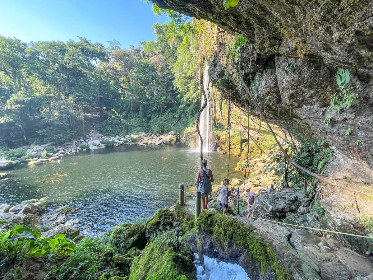 A lady and two young girls, walking down the path, from the cave towards the waterfall, at Misol-Ha, Palenque.