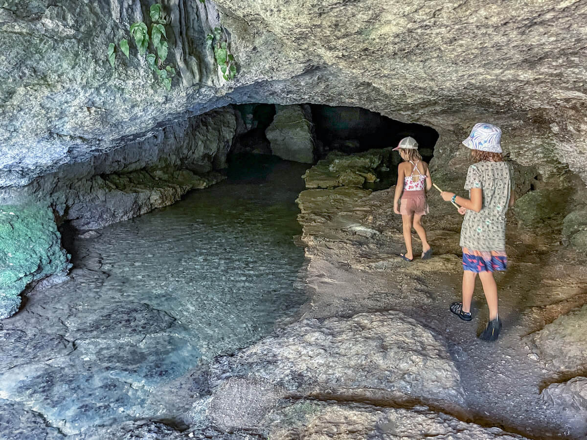 Two young girls entering the grotto / cave at Misol Ha, Palenque.