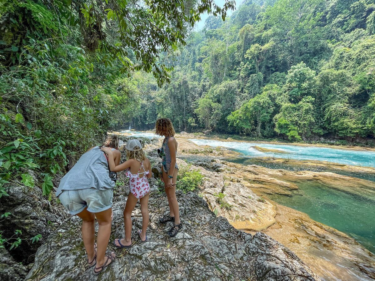 A mother and her two young daughters, at the top of Agua Azul, standing beside the river looking towards La Boquilla