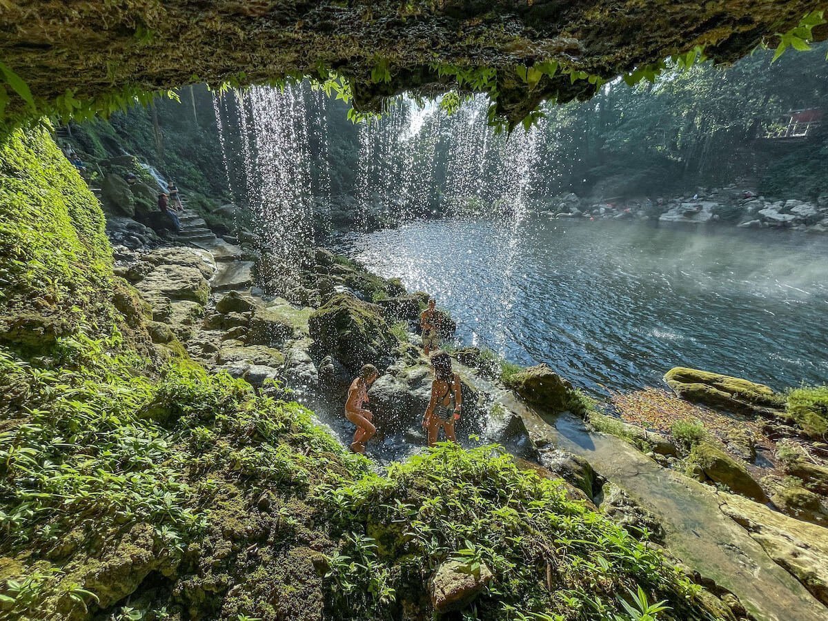 Two young girls showering in the waterfall at Misol Ha, Palenque