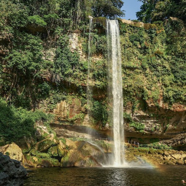 An image of the large waterfall at Misol-Ha, Palenque. Taken from down at the swimming hole, across the natural lagoon and with the walking track shown behind the waterfall.