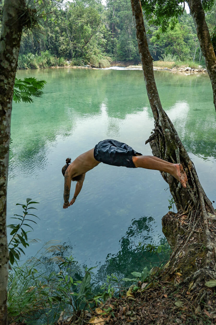 A man diving into a natural swimming hole at Agua Azul, Palenque.