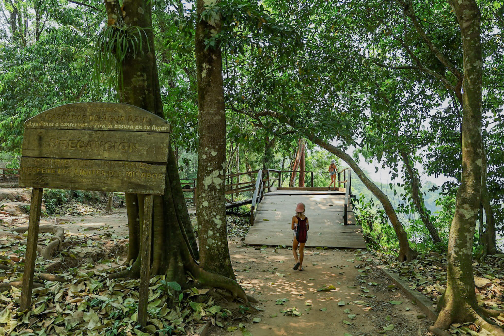 A child wearing a backpack walking towards a mirador / viewing platform at the Agua Azul cascadas at Palenque