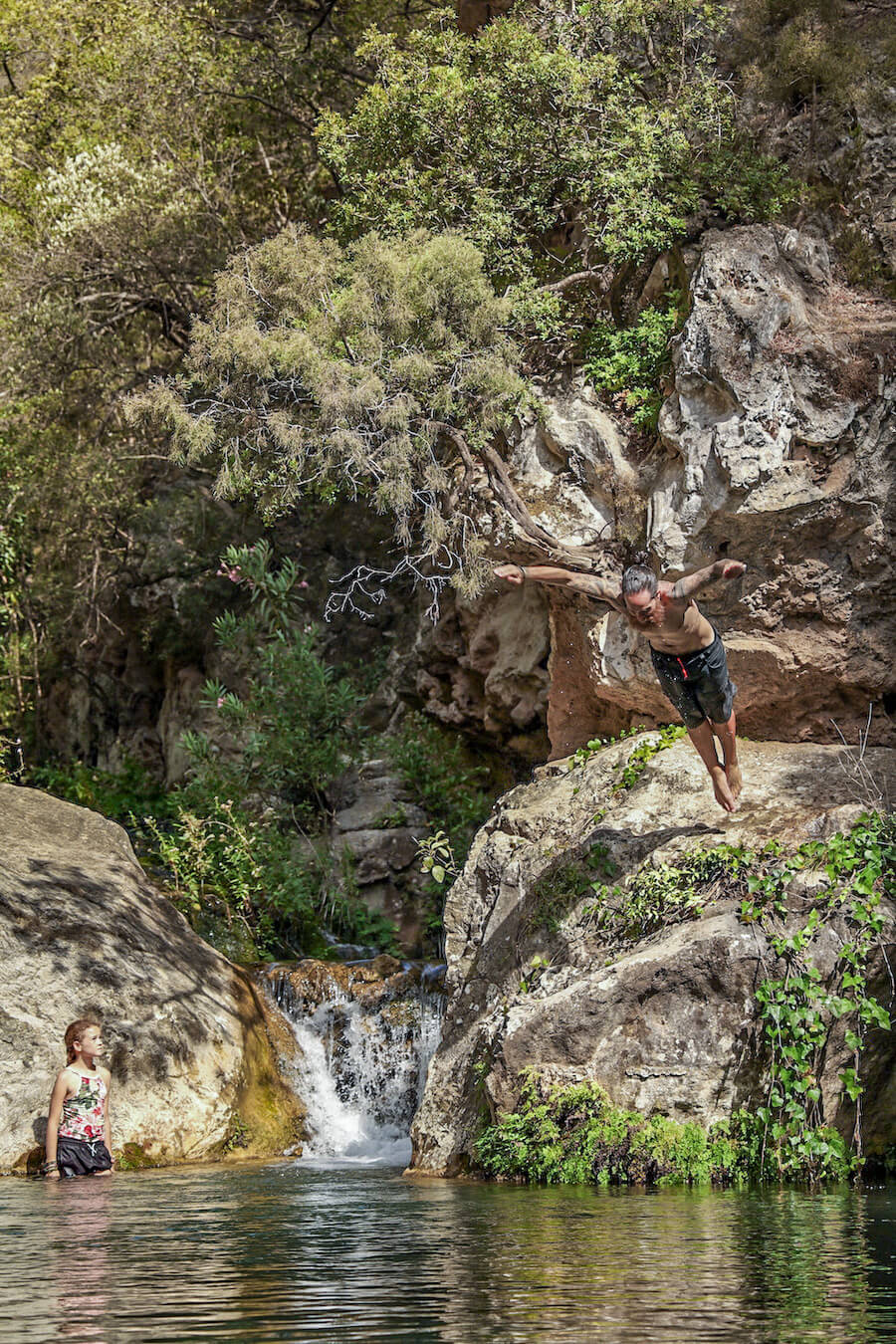 A man dives into a waterhole on the trails of Akchour and God's Bridge on a day trip from Chefchaouen, Morocco
