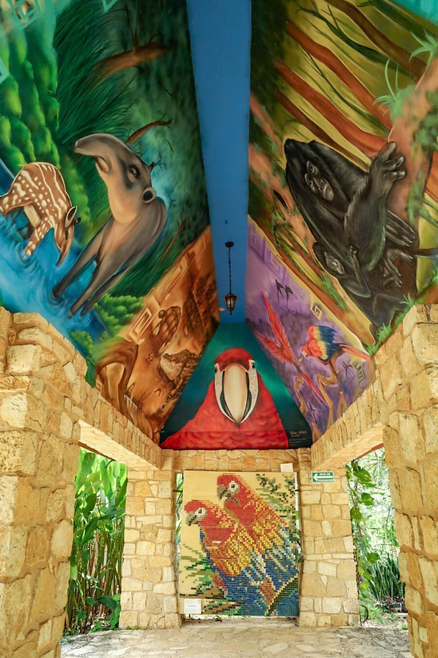 A colorful, painted, vaulted archway, displaying various wildlife.