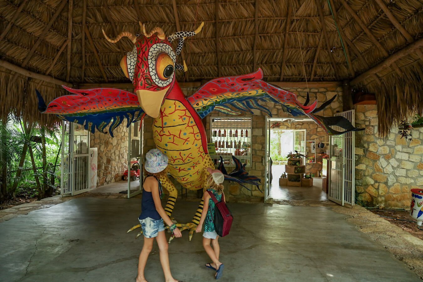 Two young girls playing in the entrance of Aluxes Ecopark, Palenque, Mexico.