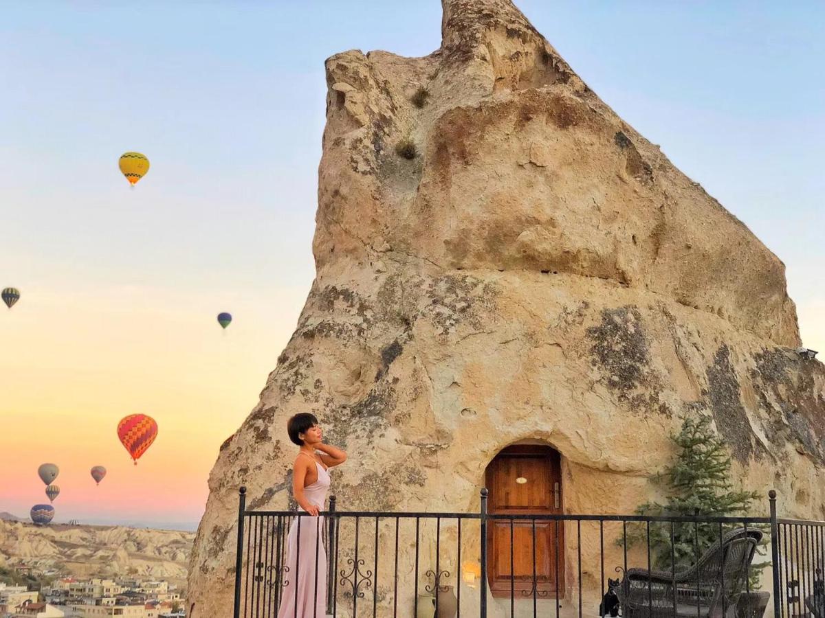 A woman stands in front of her cave room at the Arif Cave Hotel in Cappadocia.