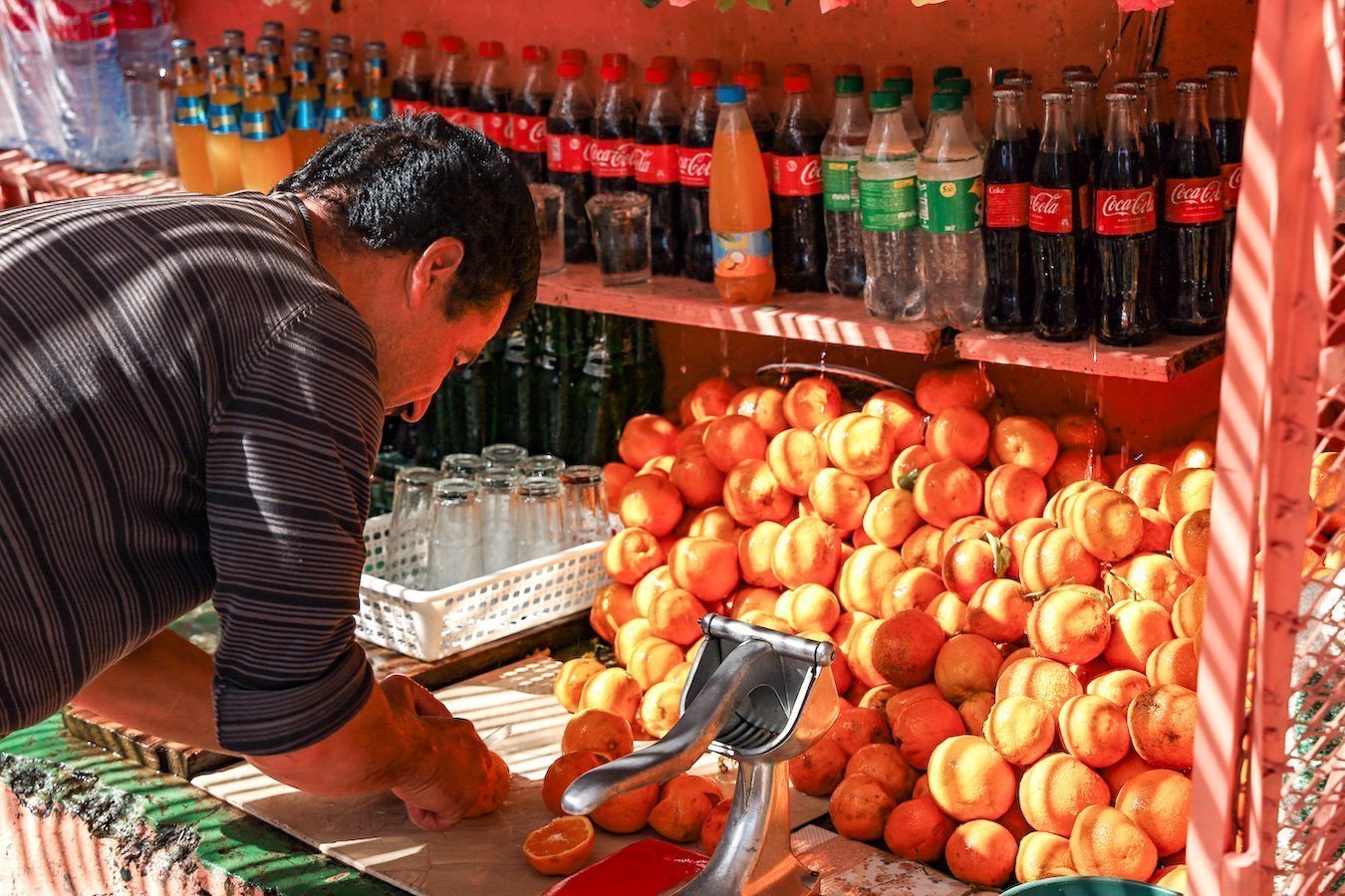 A man prepares freshly squeezed orange juice for trekkers hiking in the Atlas Mountain ranges.