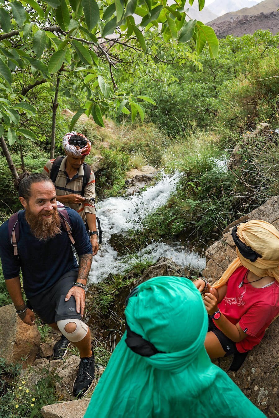 Family and tour guide trekking in the Atlas Mountain find a small spring and waterfall.