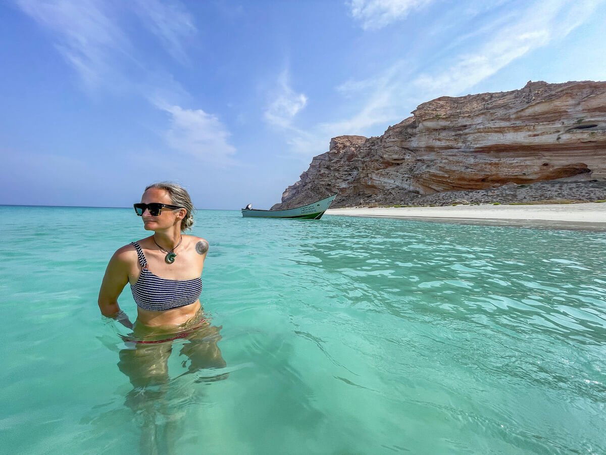 woman swims in the crystal blue waters of Socotra - and many people ask if it is safe to travel to this island