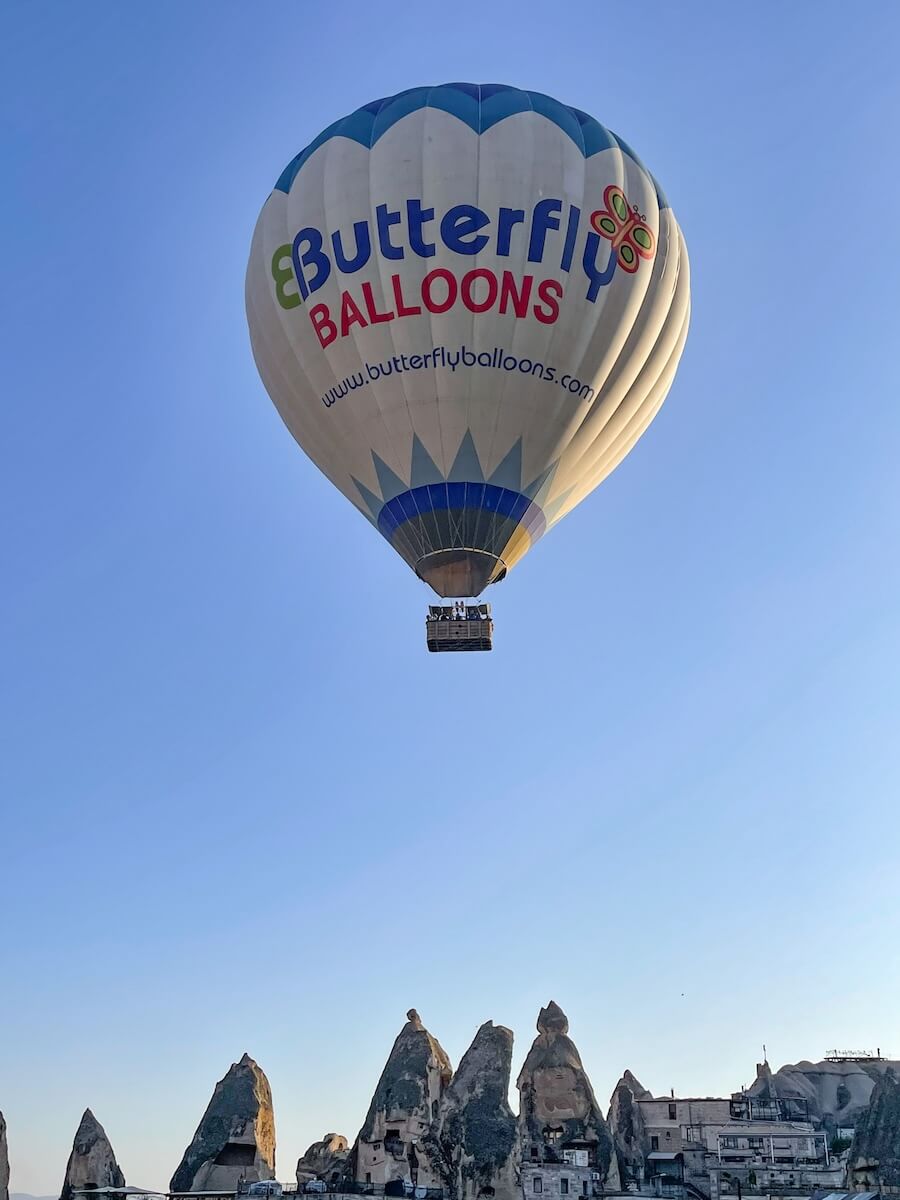 A Butterfly Balloons hot air balloon flies over cave hotels in Cappadocia.