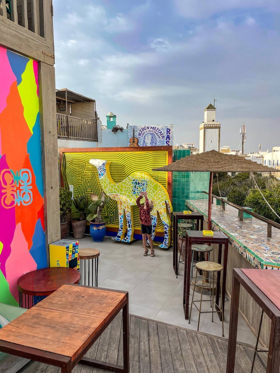 Child dances in front of the decoration camel in Taros Rooftop Bar in Essaouira