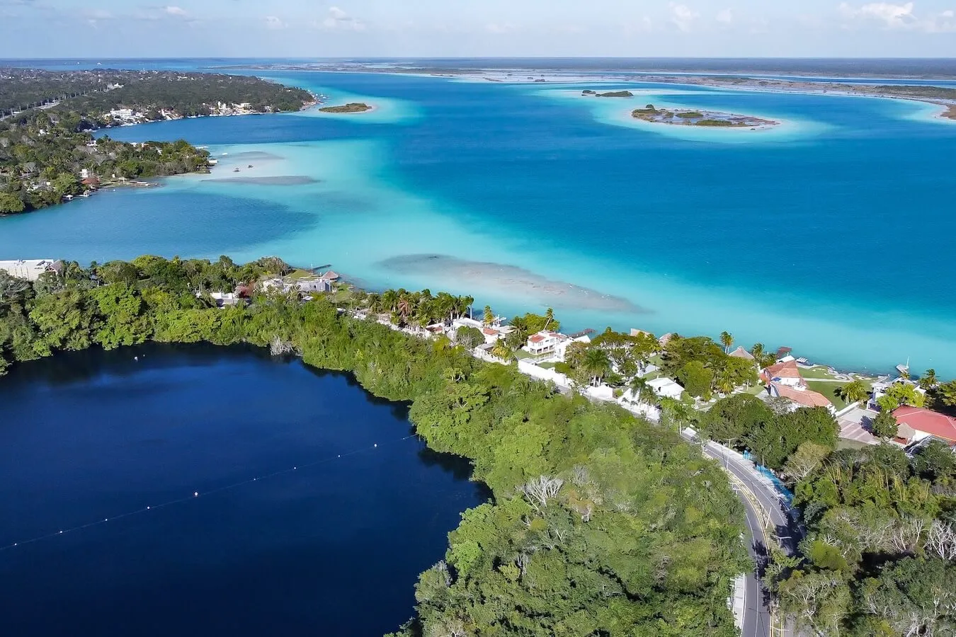 Drone image of the blended blue waters of the Bacalar Lagoon (AKA) Lake of Seven Colours. It's showing Cenote Azul, Cenote Esmeralda and Cenote Cocalitos - things to do in Bacalar