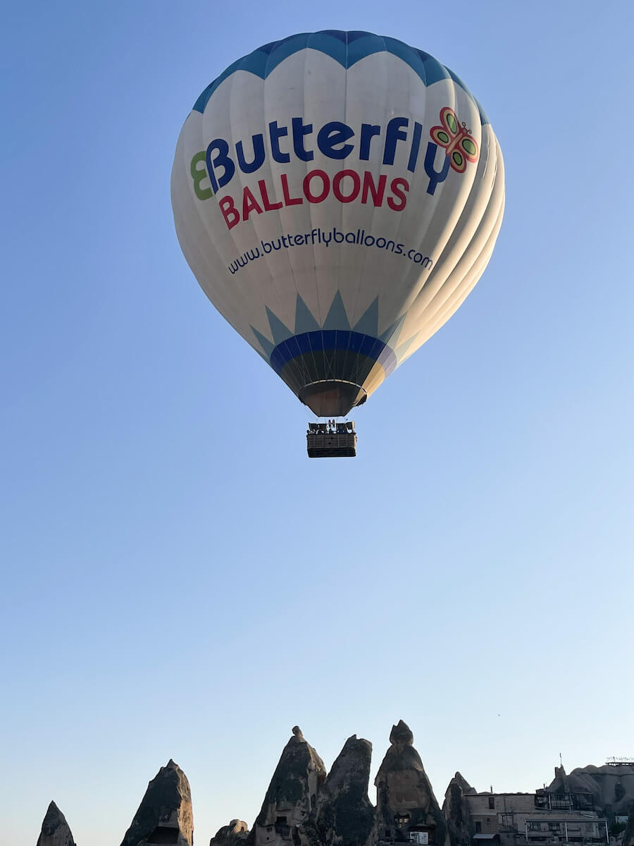 Butterfly balloon flys over fairy chimney in Goreme.