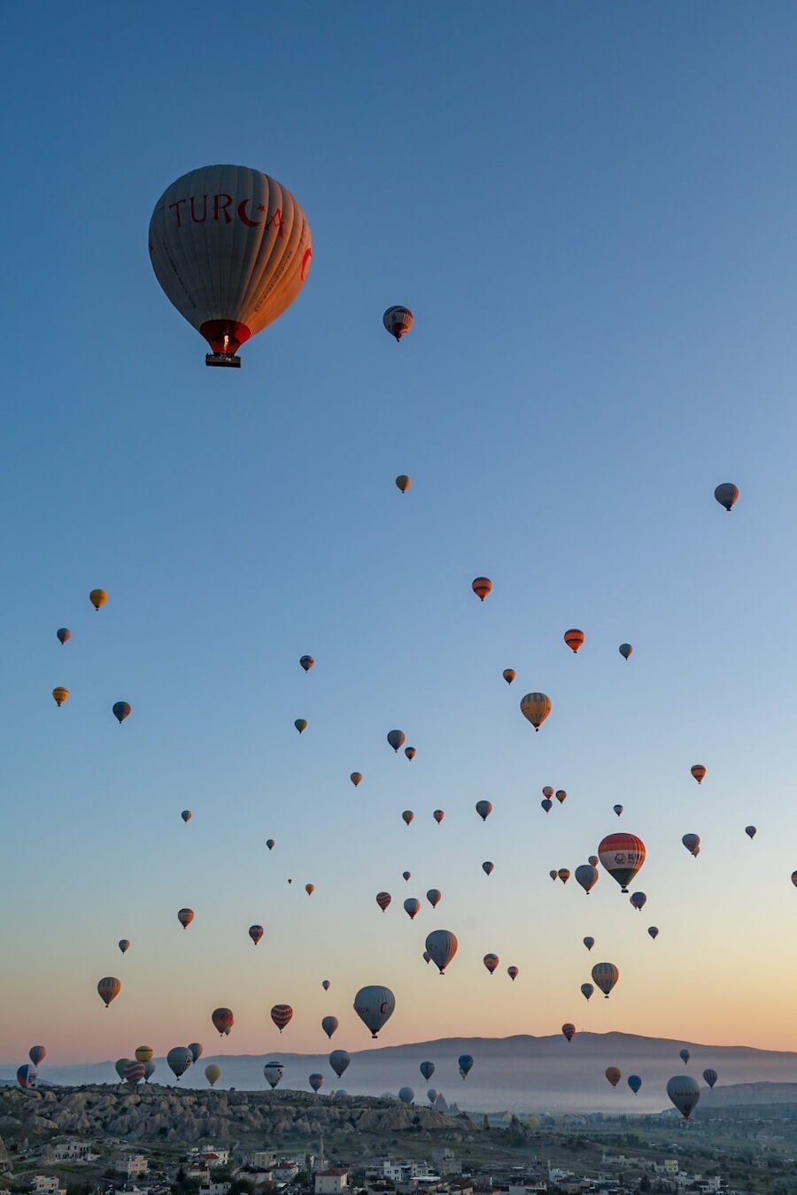 Hot air balloons fill the sky over Goreme, a bucket list experience when visiting Cappadocia in Turkey
