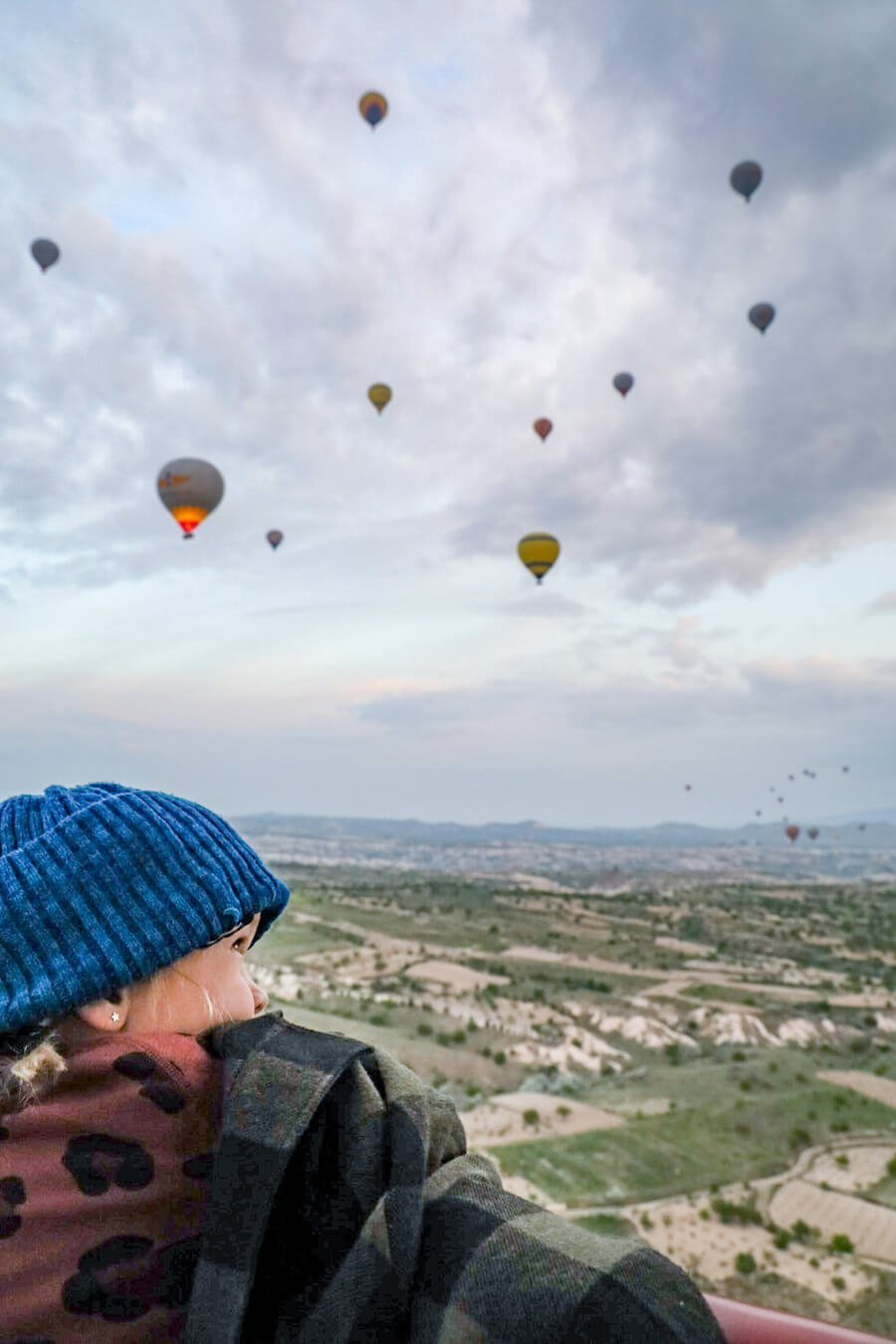 A young kid looks to the sky during a hot air balloon flight in Cappadocia.