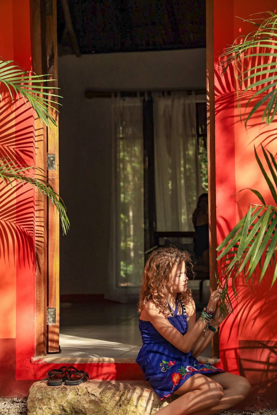 A child sits at the entrance of a bungalow at Cenote Secreto Maya near Valladolid.