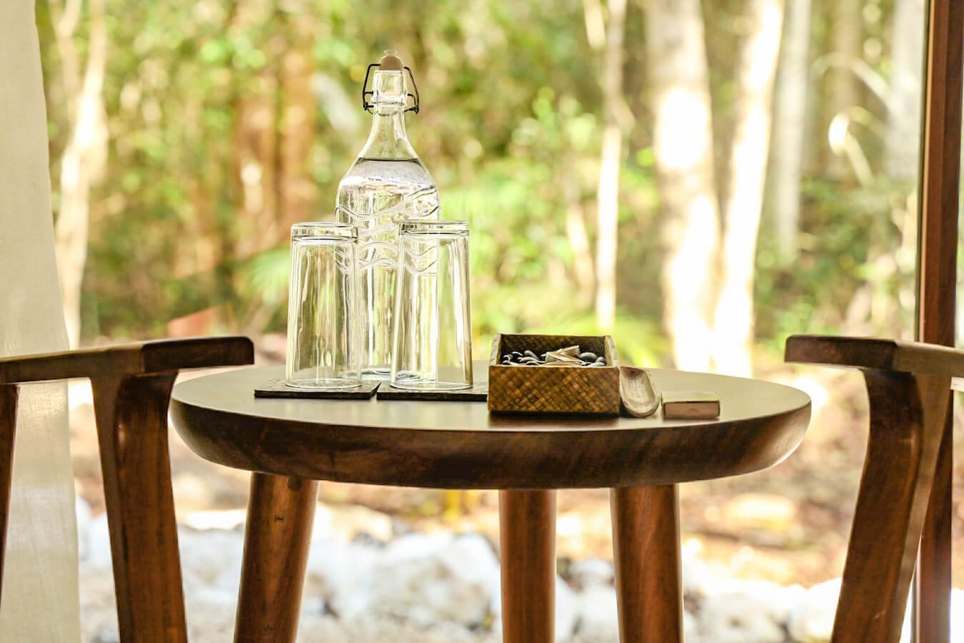 A glass jar with glasses placed in a hotel room, to support sustainable tourism.