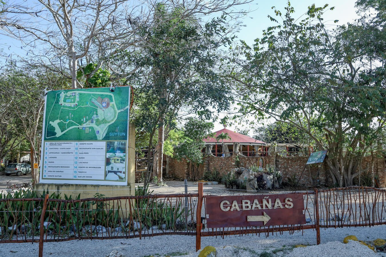 A sign pointing towards the cabins at a popular cenote complex in Valladolid.