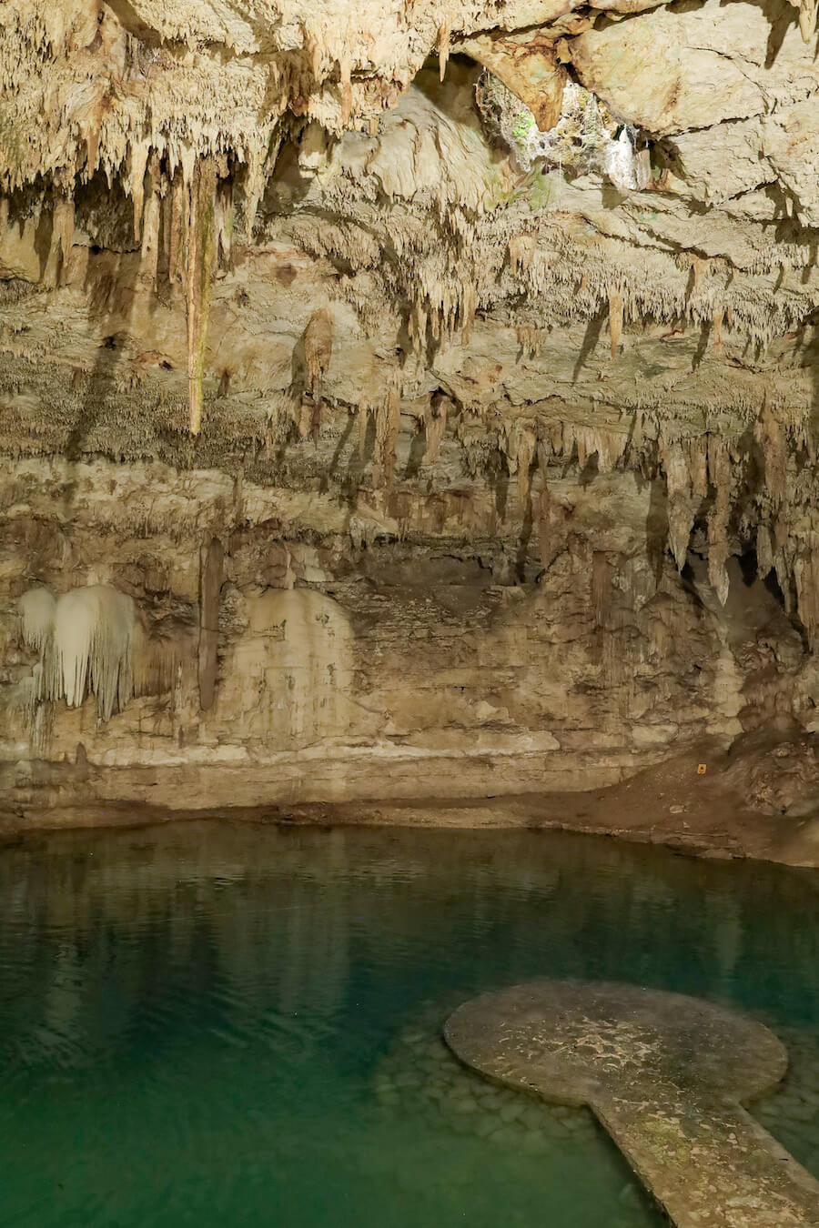 The Suytun Cenote circular platform under the hole in the vaulted ceiling and stalactites.