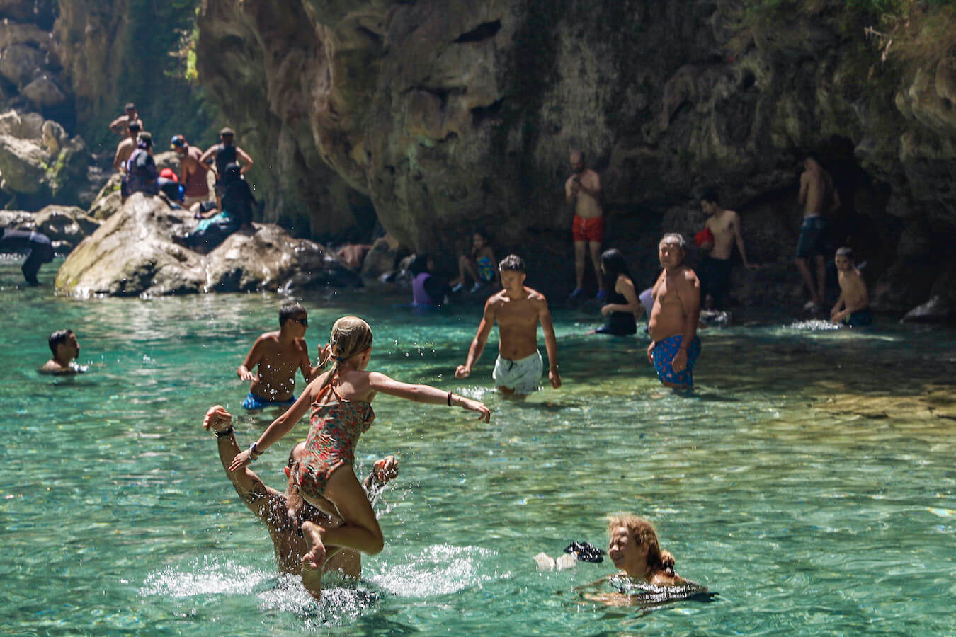 A family swim in the cold river under the God's Bridge near Chefchaouen, Morocco - a unique destination in a Morocco itinerary