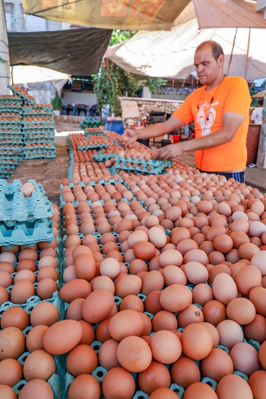 A man sets out eggs at the Chefchaouen Monday and Thursday souq market - a perfect Chefchaouen itinerary activity