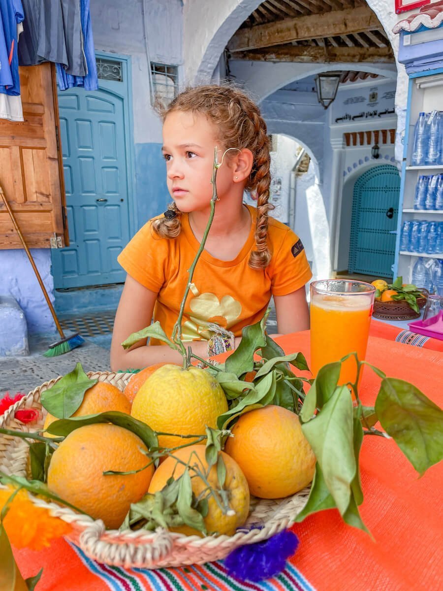 A girl drinking orange juice in Chefchaouen Morocco