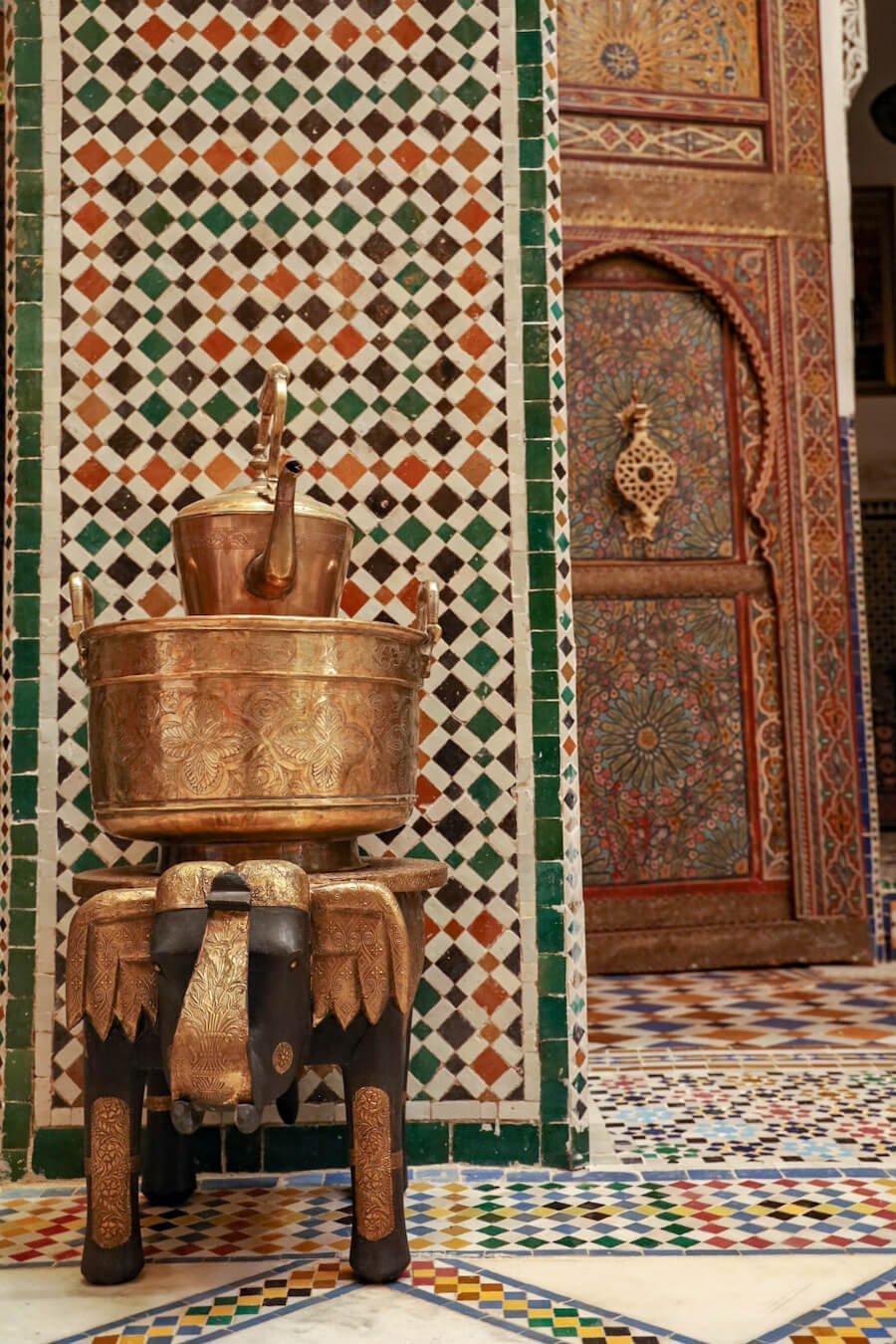 A carved elephant and beautiful tiles laid in a riad in Fes, Morocco