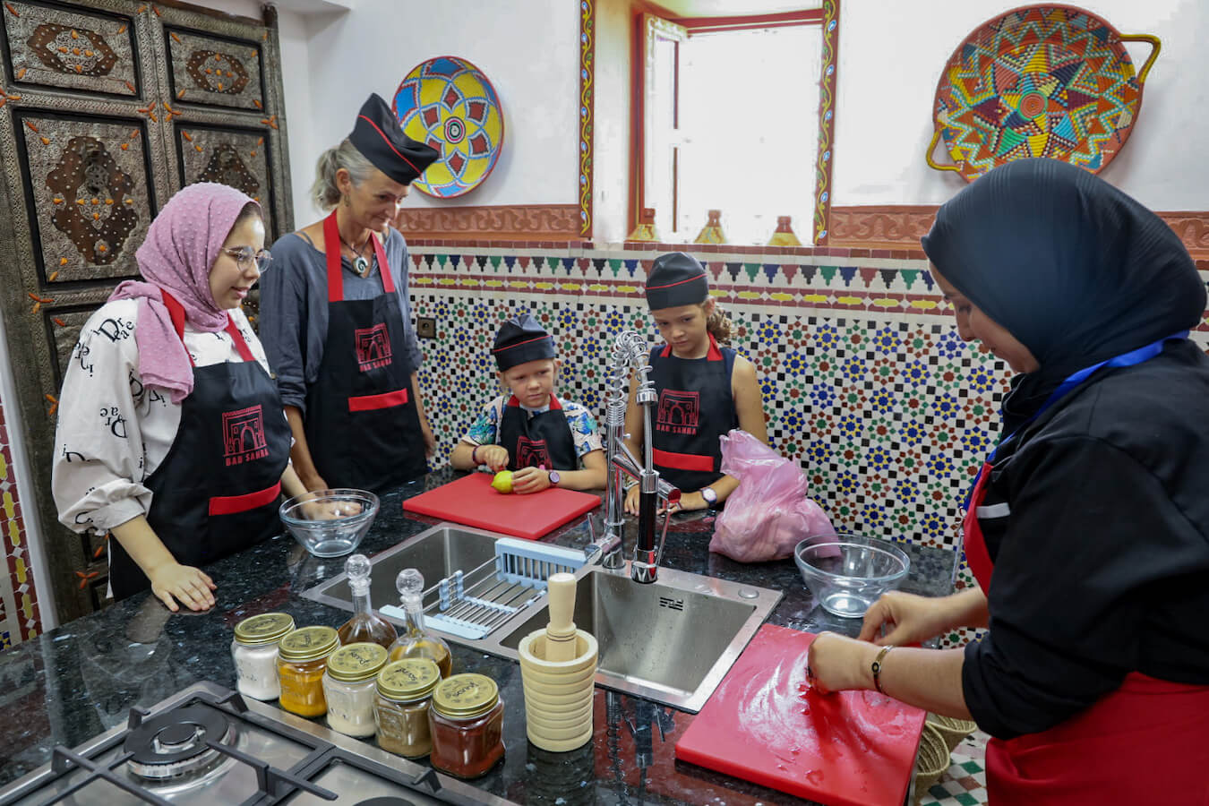 Family watch the chef cutting a lemon to make a tagine in a cooking class in Morocco