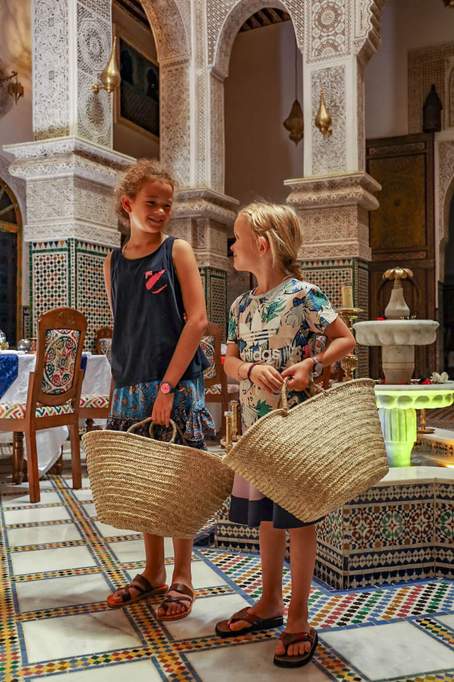 Two kids get ready with woven baskets for a Cooking Class in Fes Morocco