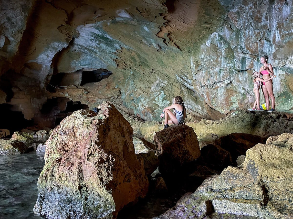 A family admire the view of the Cova Tallada sea caves and lagoon in the Montgo Natural Park near Denia and Javea / Xabia in Spain