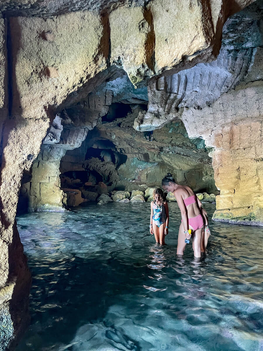 A family walk through the sea cave of Cova Tallada near Javea and Denia in Spain