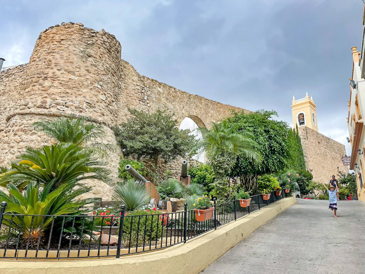 A family on a day trip from Javea, walk through the old town in Calpe, Spain.