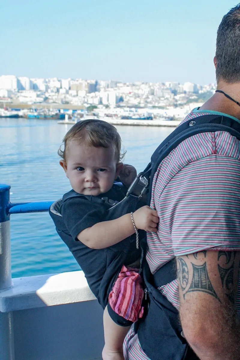 A baby in a backpack with her father, on the ferry and on her way to Tangier from Tarifa, Spain.