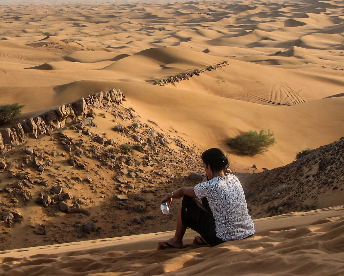 Girl looks out towards the sand dunes, landscape and beautiful desert views
