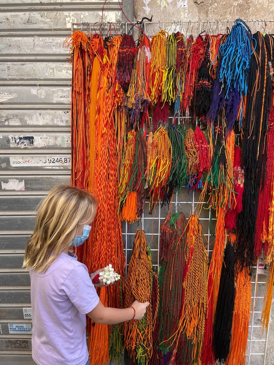 Girl looks through Shiva temple merchandise at the Dubai Creek in the old town.