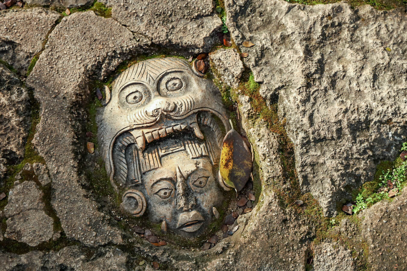 A Mayan mask carving set into the footpath in the Yucatan in Mexico